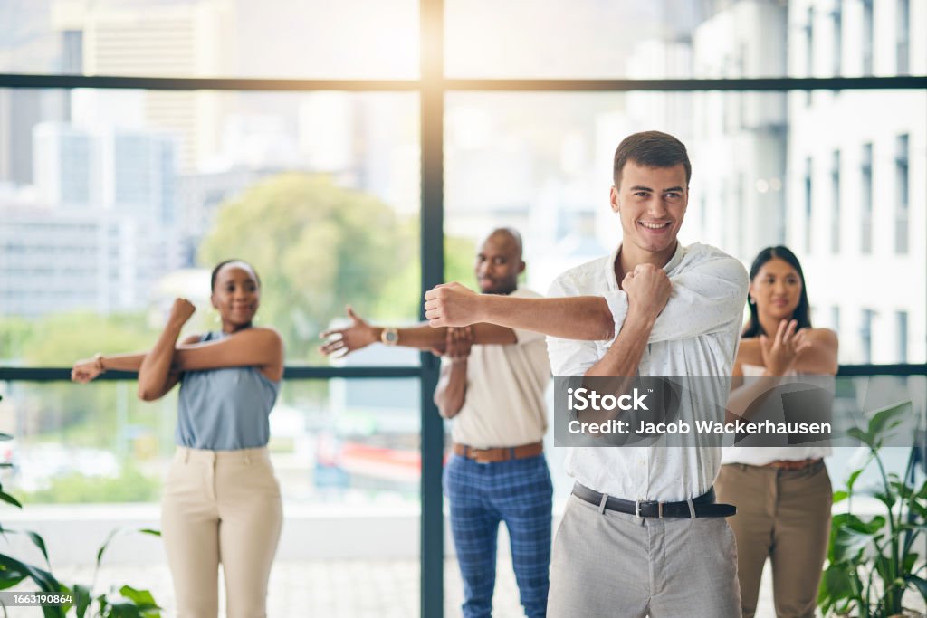 Personas realizando estiramientos para mejorar su bienestar físico en el trabajo